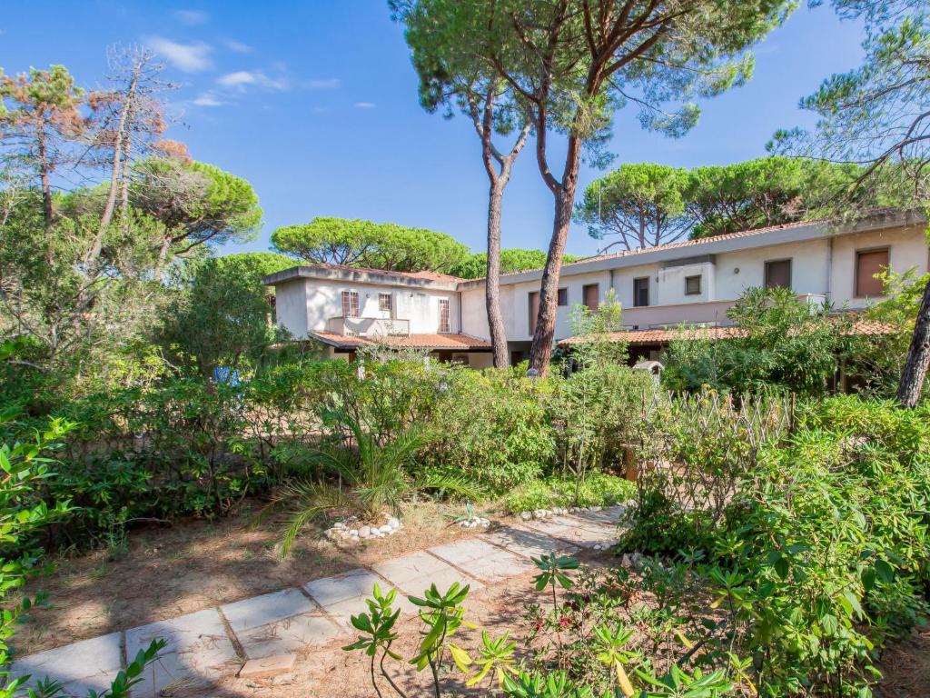 einen Blick nach außen auf ein Haus mit Bäumen und Sträuchern in der Unterkunft Holiday Home Barracuda by Interhome in Principina a Mare