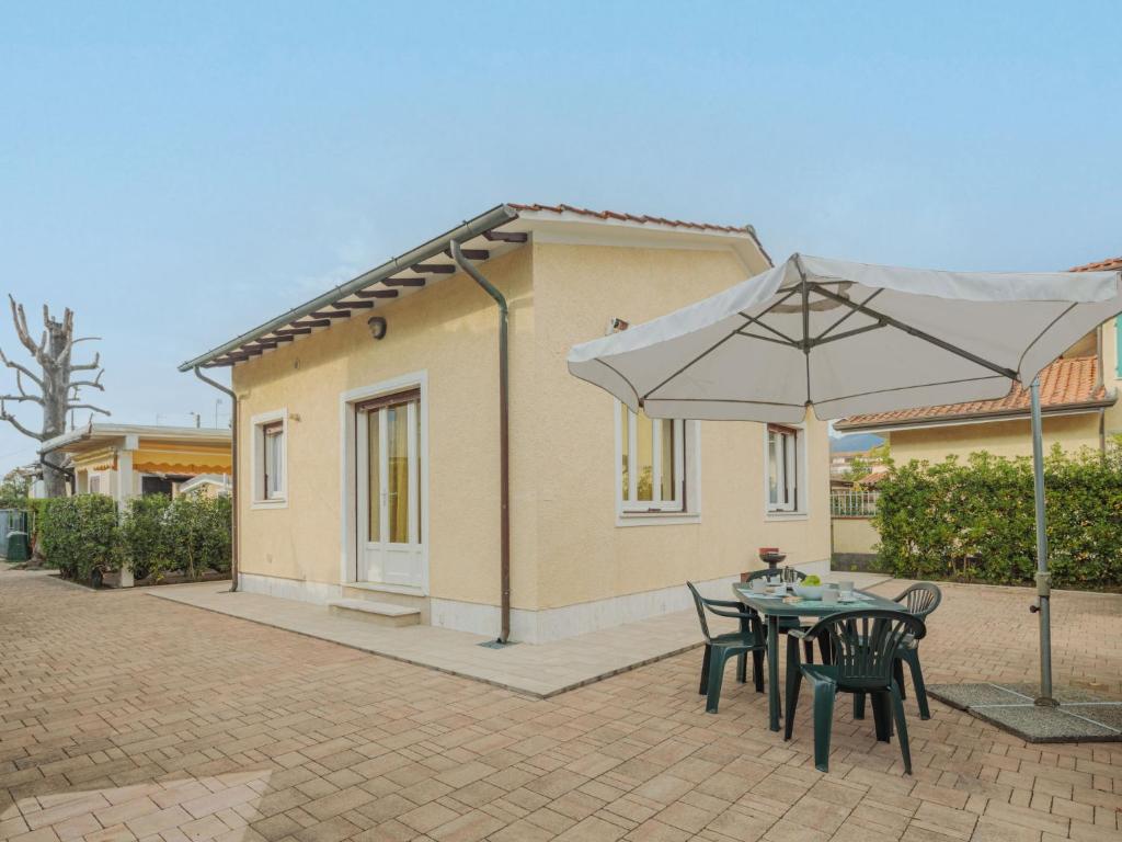 a table and chairs with an umbrella in front of a house at Holiday Home Manuela by Interhome in Marina di Pietrasanta