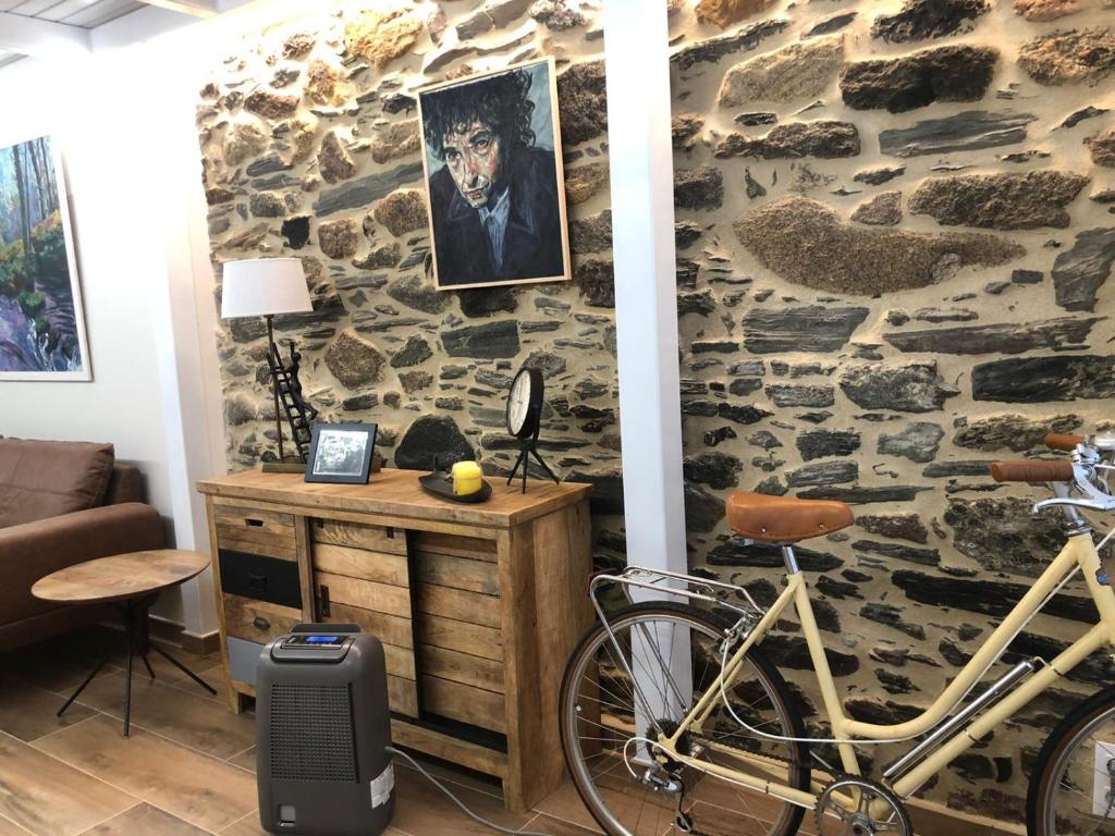 a room with a stone wall with a bike parked against it at Apartamento completamente equipado en Pontedeume. in Puentedeume