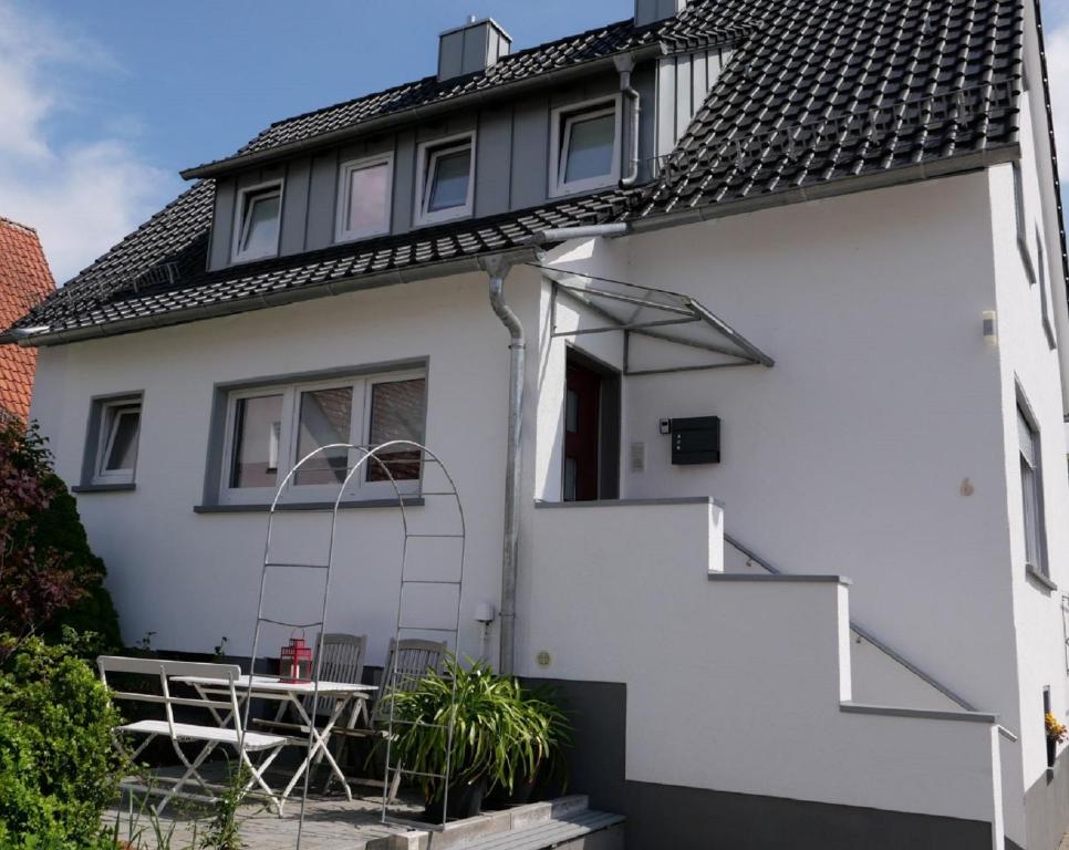Una casa blanca con una escalera a un lado. en Ferienwohnung Blumengarten en Marburg an der Lahn