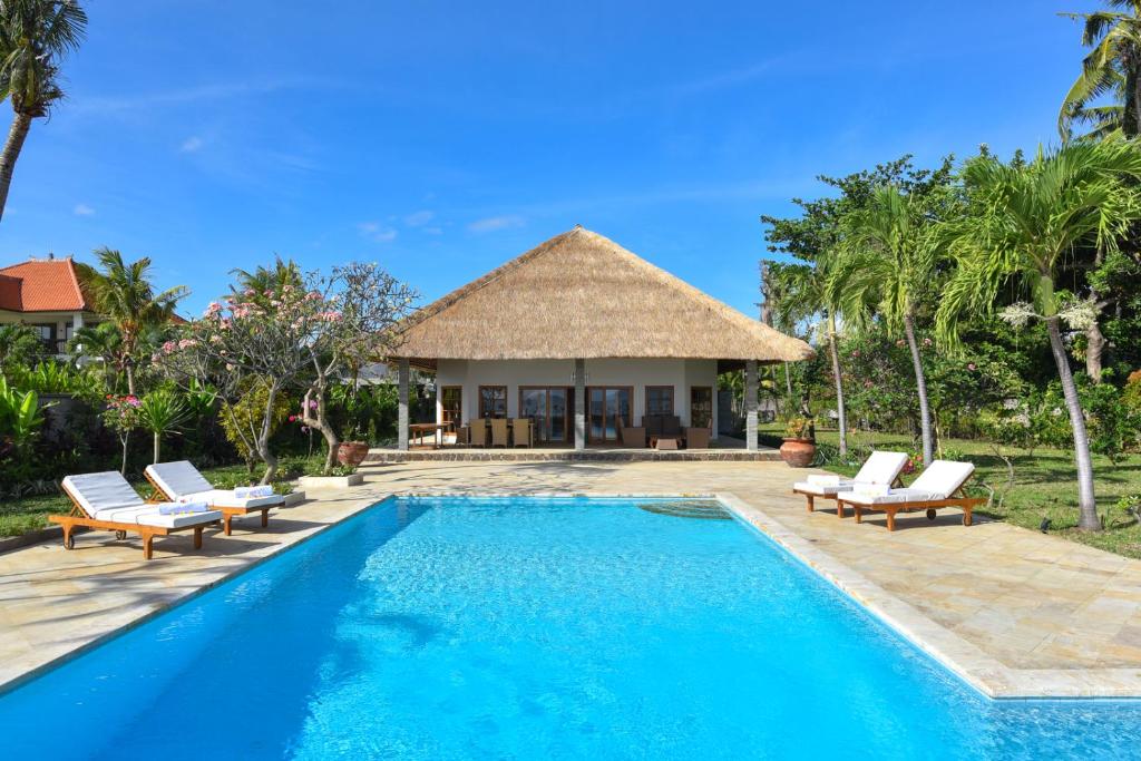 Una villa con piscina y un complejo turístico. en Villa Duyung, en Buleleng