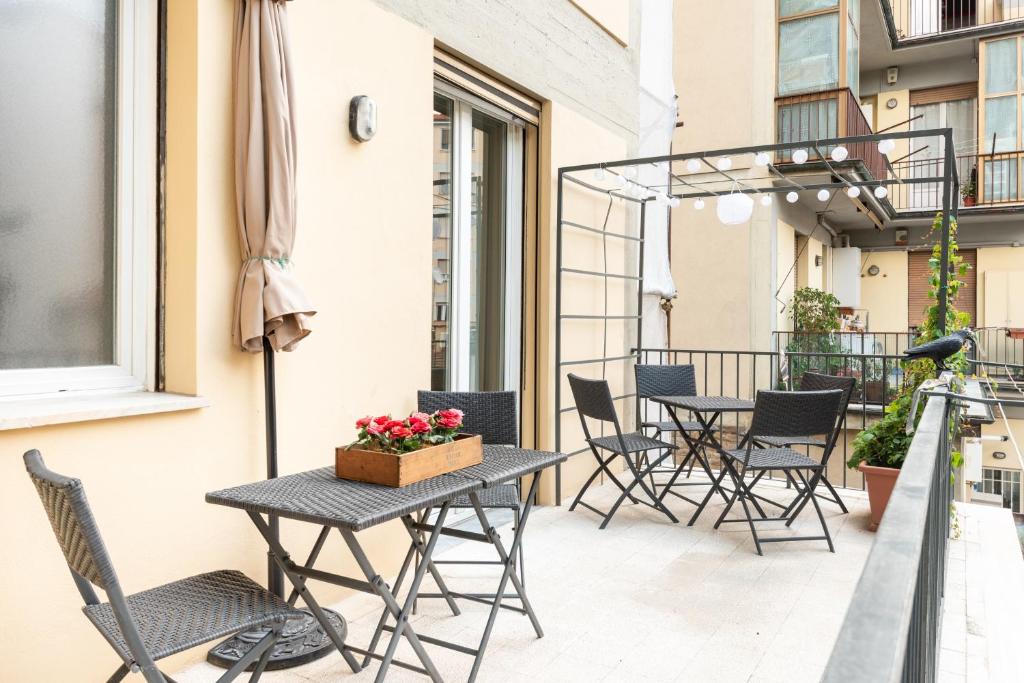 eine Terrasse mit Tischen und Stühlen auf dem Balkon in der Unterkunft Modern Flat River View Terraces Lift Free Parking in Florenz