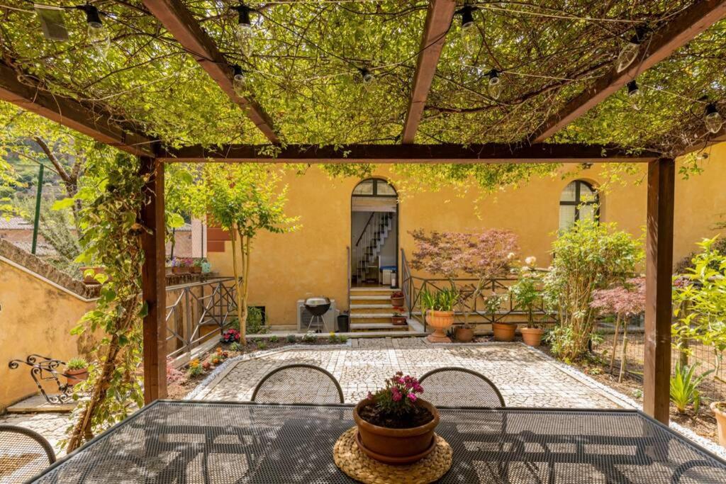 un patio con una mesa y una casa en Secret Garden Siena, en Siena