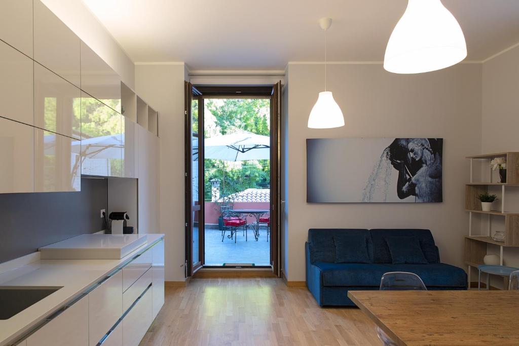 Una cocina y una sala de estar con un sofá azul. en La Terrazza sul Parco Suite, en LʼAquila