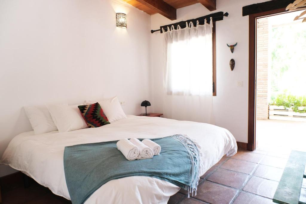 a bedroom with a large white bed with towels on it at The Wild Olive Andalucía Citrus Suite in Casares