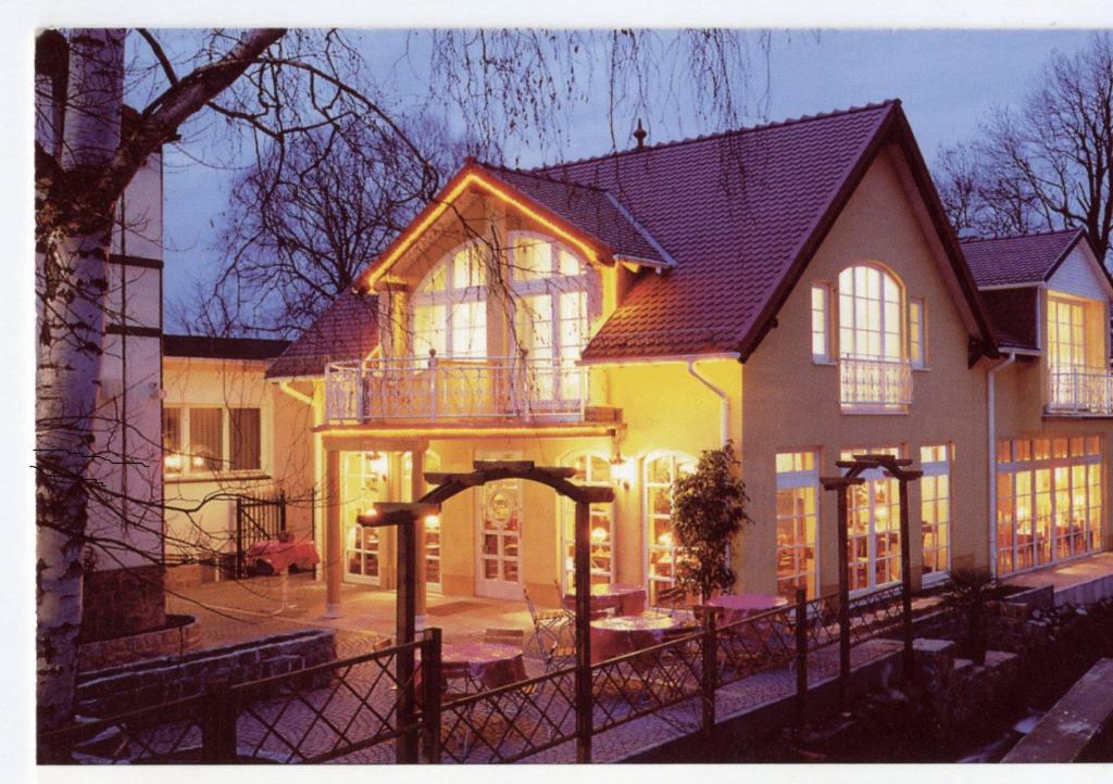 ein großes Haus mit einem Torbogen davor in der Unterkunft Gasthaus Stobbermühle in Buckow