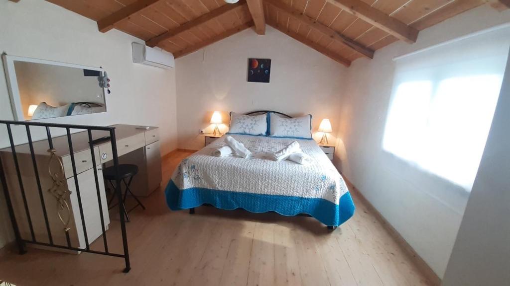 una camera da letto con un letto con un piumone blu e bianco di White Manolia Cottage a Kato Korakiana
