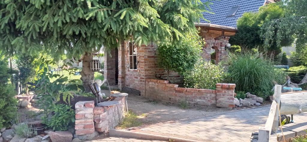 a brick house with a tree and a brick wall at Pokoje Gościnne Cisowa in Zielona Góra