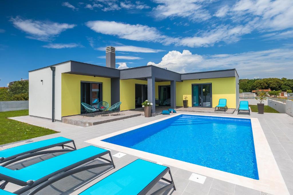 una villa con piscina di fronte a una casa di Kuća za odmor INES a Pola (Pula)