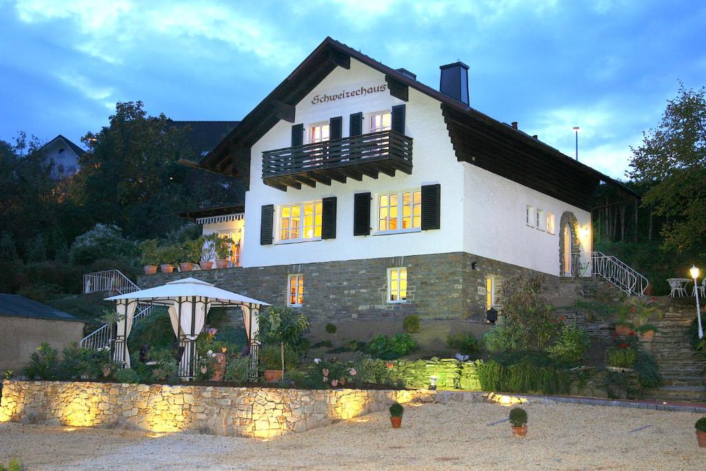 ein großes Haus mit einem Pavillon davor in der Unterkunft Schweizerhaus am Kurpark in Boppard