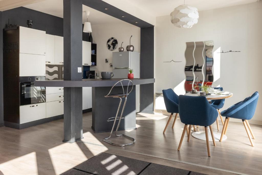 uma cozinha com cadeiras azuis e uma mesa num quarto em Albert Goupil - LAVALOC em Laval
