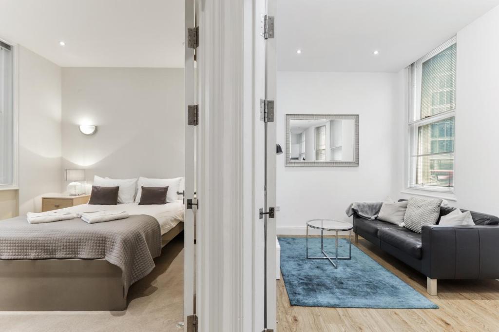 um quarto com uma cama e um sofá em Cosy 1 Bed Apartment next to Liverpool Street Station FREE WIFI By City Stay Aparts London em Londres
