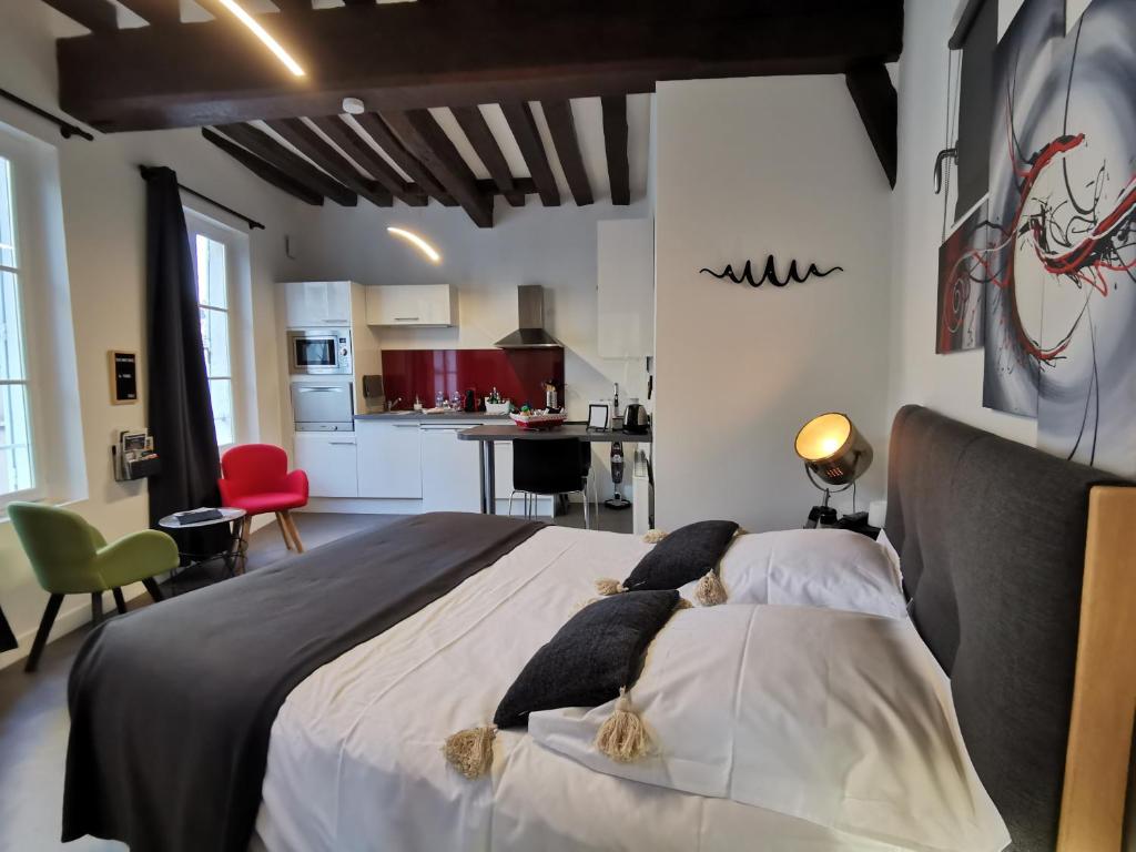 um quarto com uma cama grande e uma cozinha em Le Saint-Aignan, Nuits-chartraines, Parking privé a quelques minutes, 3 étoiles em Chartres