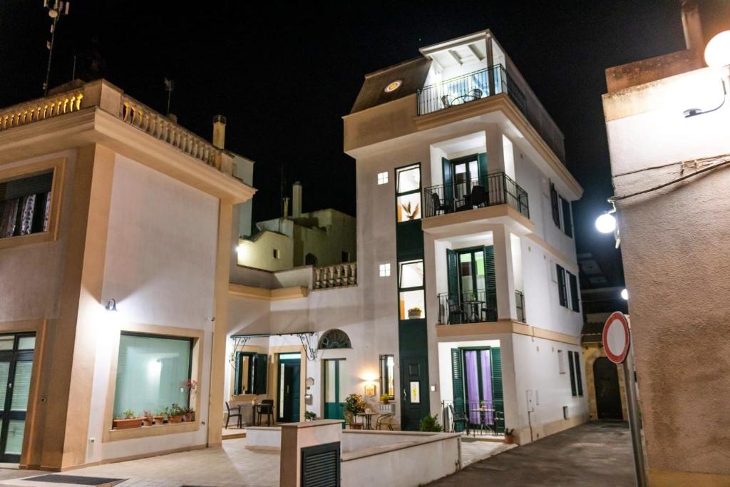 Un grand bâtiment blanc avec balcon est disponible la nuit. dans l'établissement La Torretta Dei Sogni, à Corsano