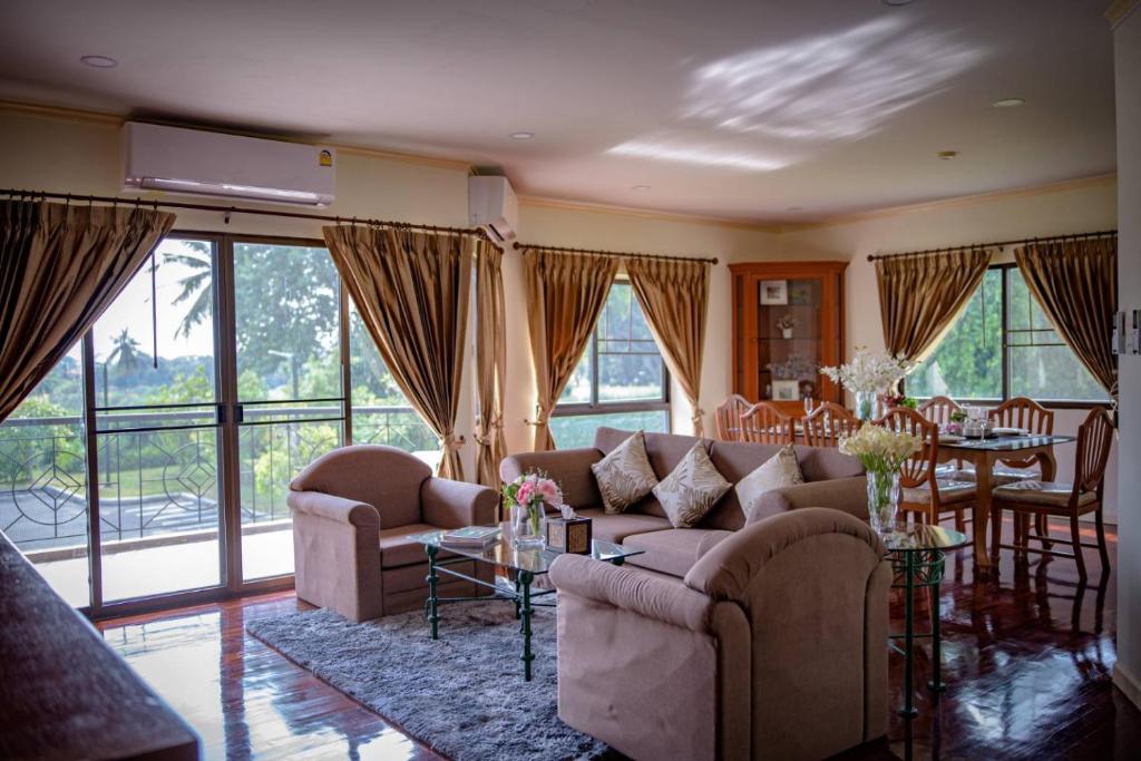 uma sala de estar com sofás e uma sala de jantar com uma mesa em Seastar Hotel and Service Apartment em Ban Chang