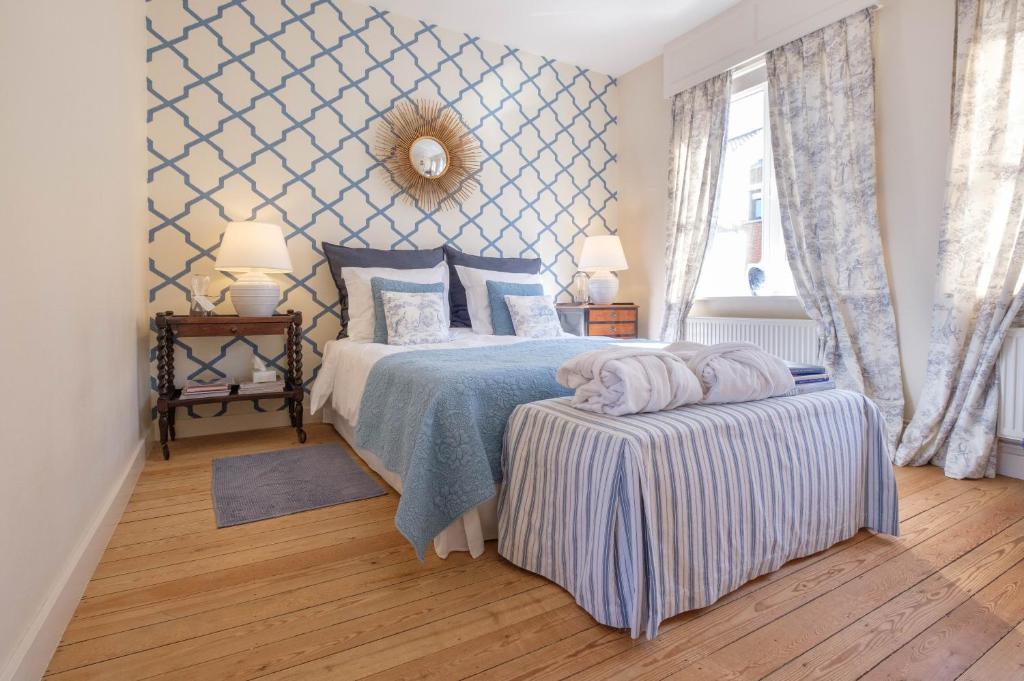 布魯日的住宿－麥班德住宿加早餐旅館，一间卧室配有一张带蓝色图案墙壁的床