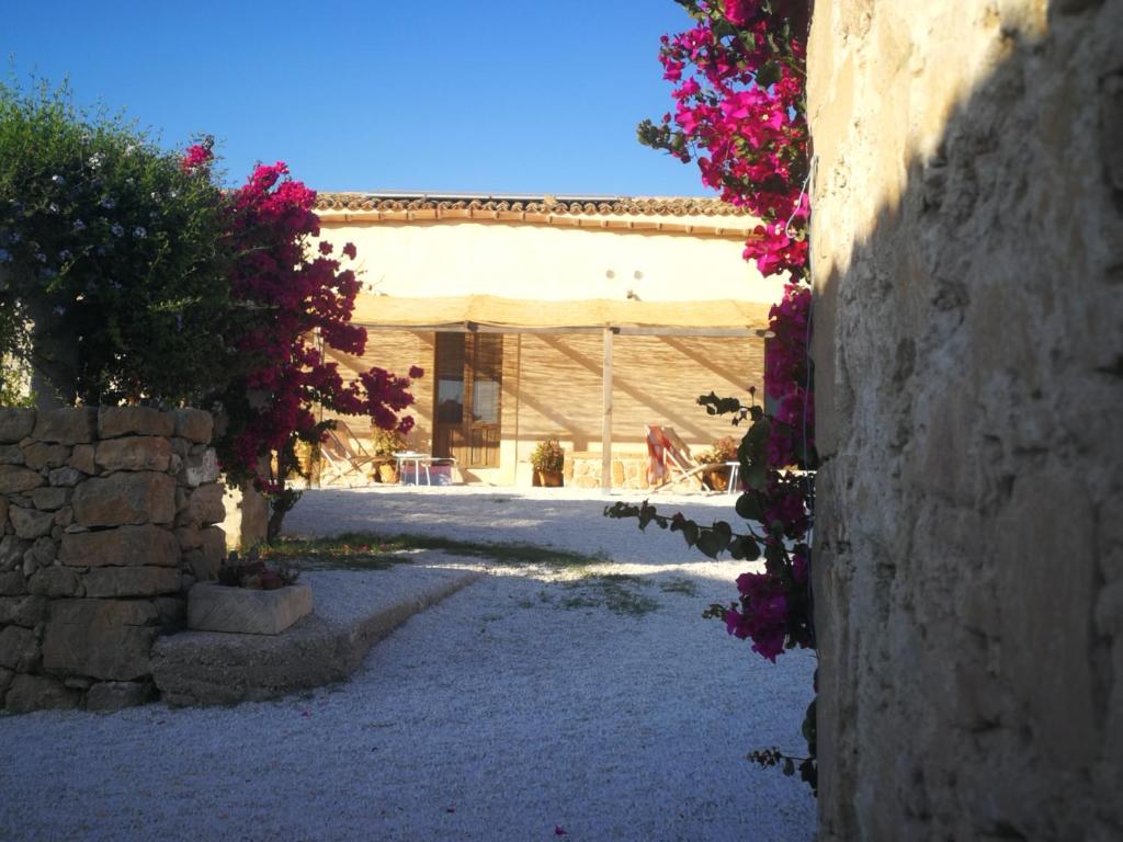 een gebouw met bloemen aan de zijkant bij Casette Marianeddi -Agriturismo Marianeddi in Noto
