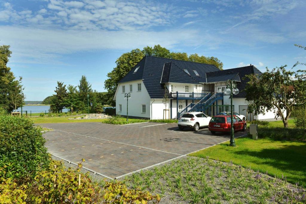 une maison avec une voiture garée sur un parking dans l'établissement STöRTEBEKER APPARTEMENTS - "BLAUES HAUS", à Ralswiek