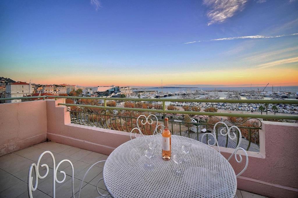 a table on a balcony with a view of a city at SUPERBE DUPLEX IDEALEMENT SITUE PROCHE PLAGES AVEC GRANDE TERRASSE VUE PORT !l A1B59 in Cannes
