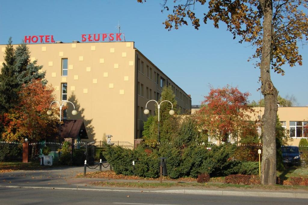 un edificio con un cartel en el costado en Hotel Słupsk, en Słupsk