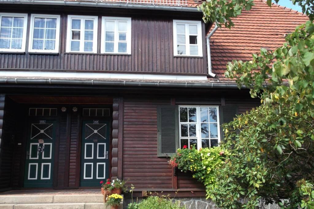 una casa in legno con porte e finestre nere di Wohnen im Holzhaus a Niesky