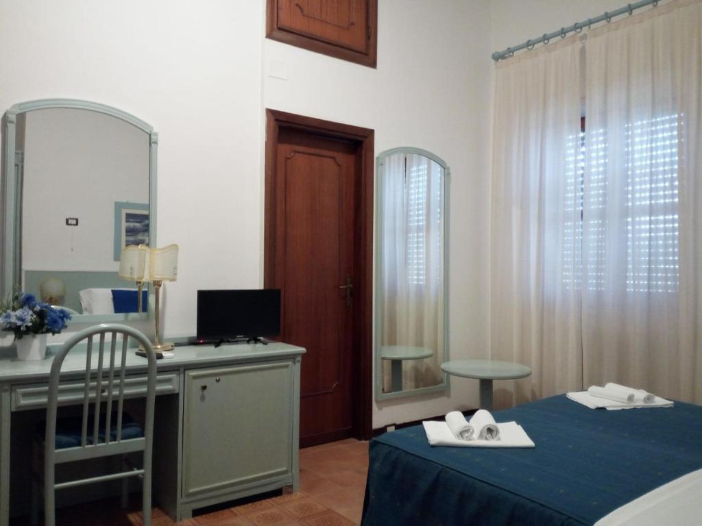 a bedroom with a desk and a computer and a mirror at Hotel Mercede 2 in San Felice Circeo