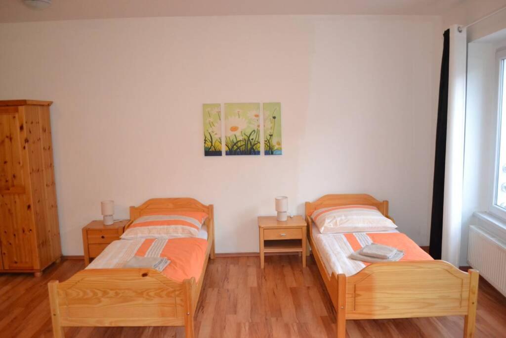 Cette chambre comprend 2 lits jumeaux et du parquet. dans l'établissement Apartment im Herzen von Neusiedl am See, à Neusiedl am See