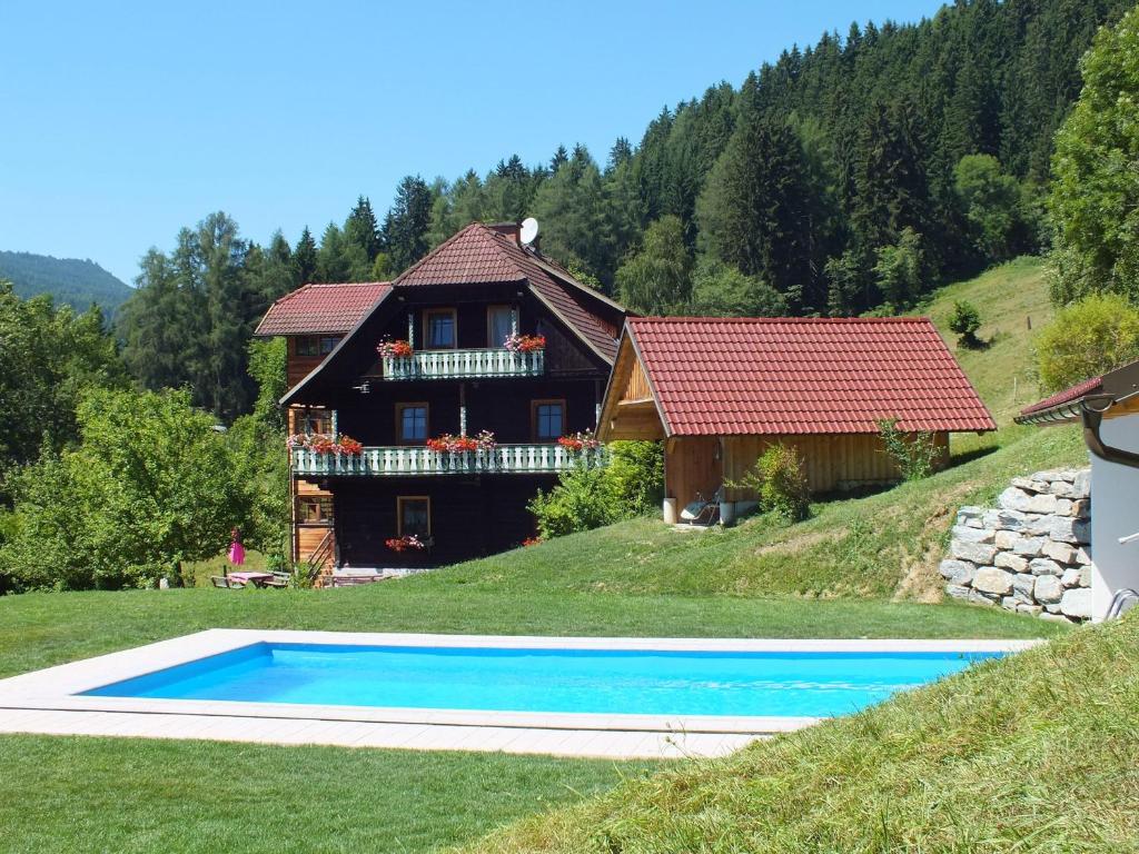 uma casa e uma piscina em frente a uma casa em Steurer Hof em Liebenfels