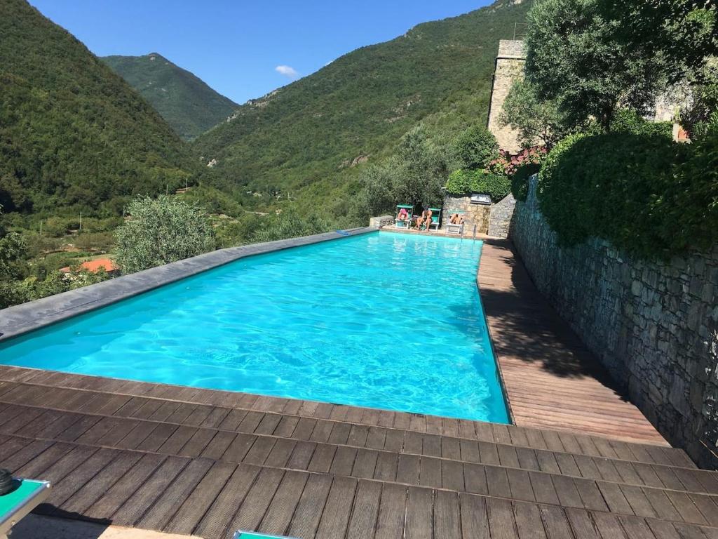 une piscine avec une montagne en arrière-plan dans l'établissement Oliveto medieval setting, à Castelbianco
