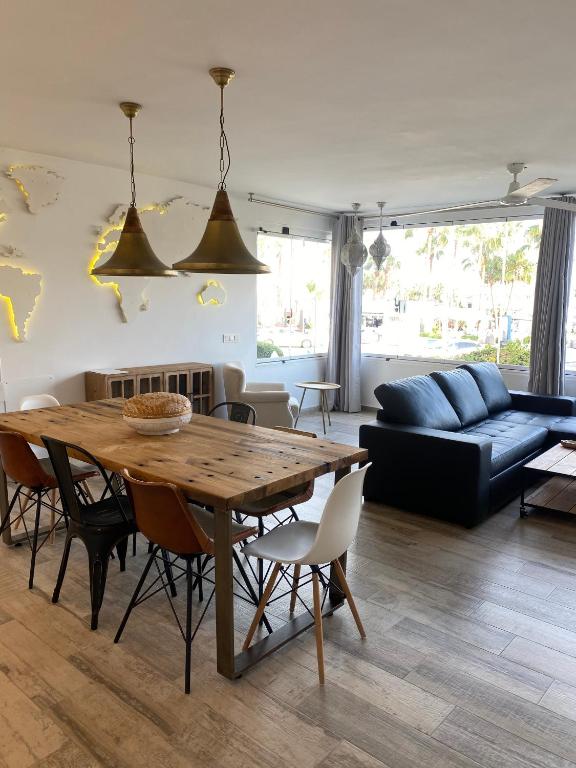 a living room with a wooden table and a couch at AlquilaEasy Windsor in Benalmádena