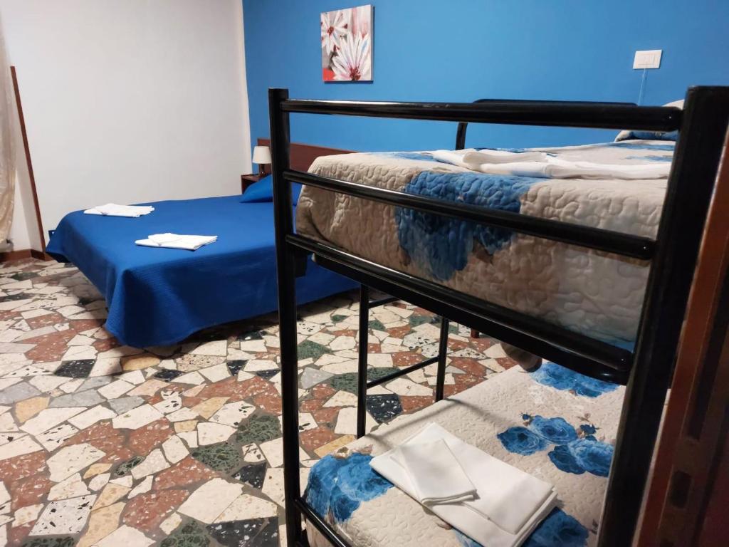 a bedroom with two bunk beds and a blue wall at Hotel Mercede 2 in San Felice Circeo