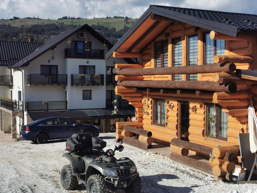 ヴァトラ・ドルネイにあるCHALET RELAXの丸太の建物前に停車するオートバイ