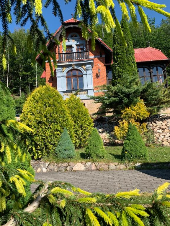 un bâtiment avec une tour d'horloge en haut dans l'établissement Leśny Dwór, à Długopole-Zdrój