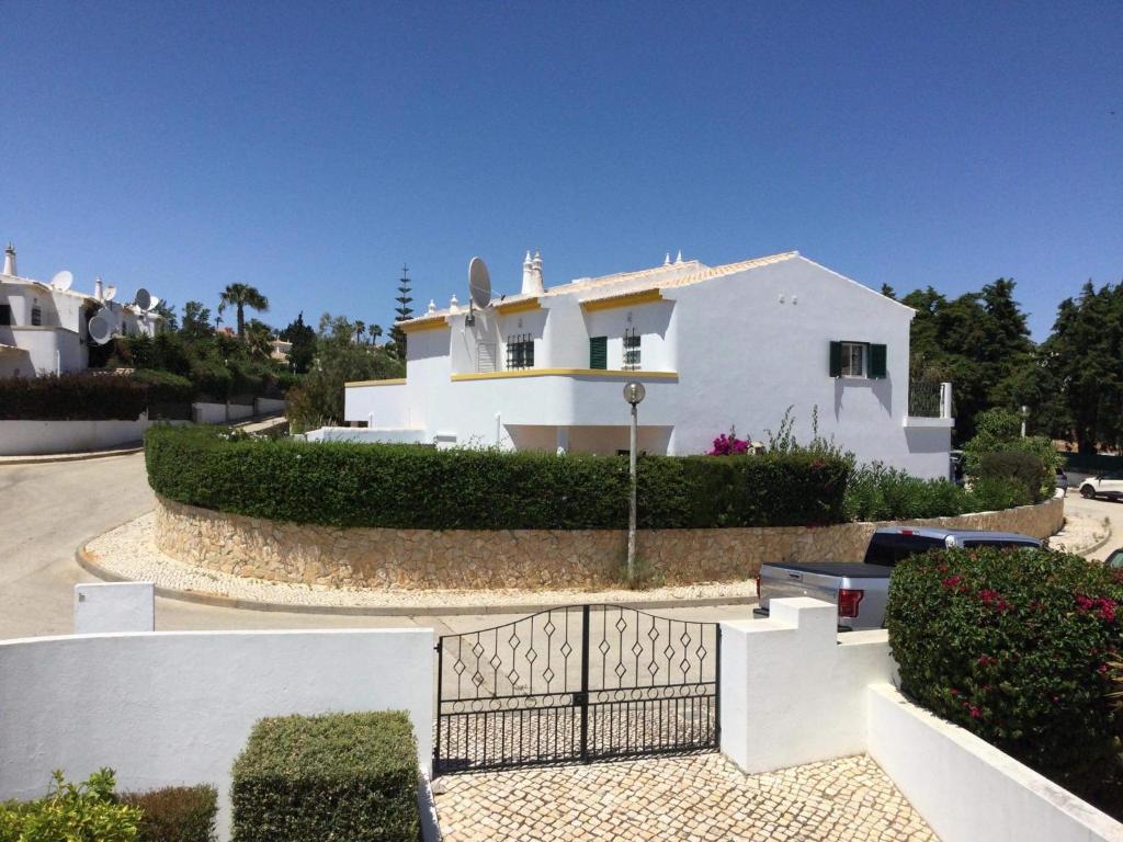 a white house with a fence in front of it at Casa Rosa Floresta in Luz
