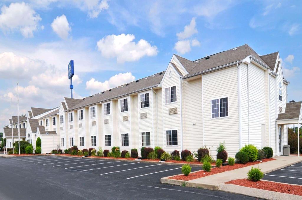 ein großes weißes Gebäude mit Parkplatz in der Unterkunft Microtel Inn and Suites Clarksville in Clarksville