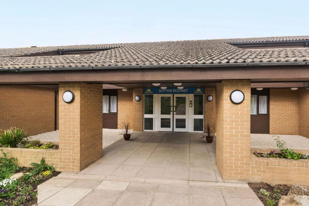 um edifício de escritórios de tijolos com uma porta da frente em Days Inn Sutton Scotney South em Sutton Scotney