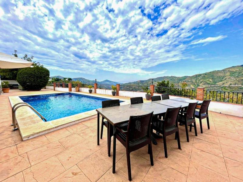 una mesa y sillas junto a una piscina en Villa La Posada, en Canillas de Albaida