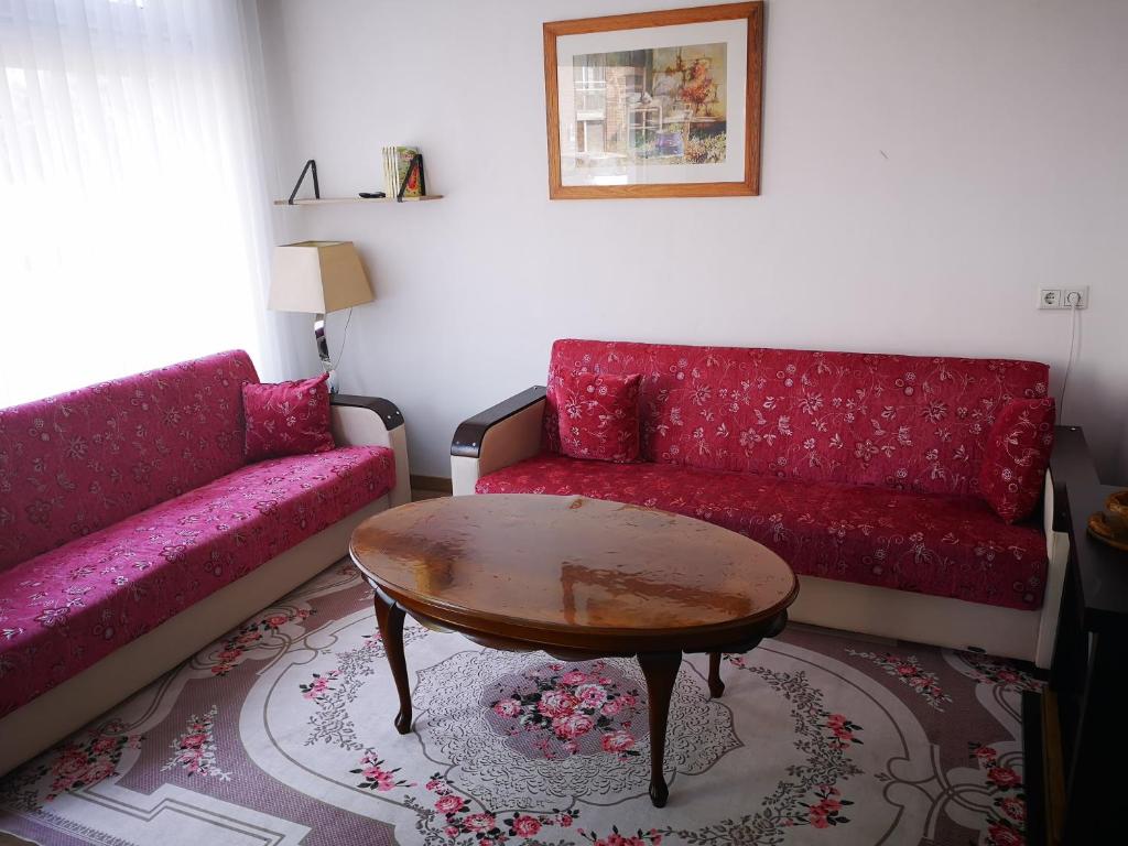 a living room with a red couch and a table at Studio Huzur in Deventer