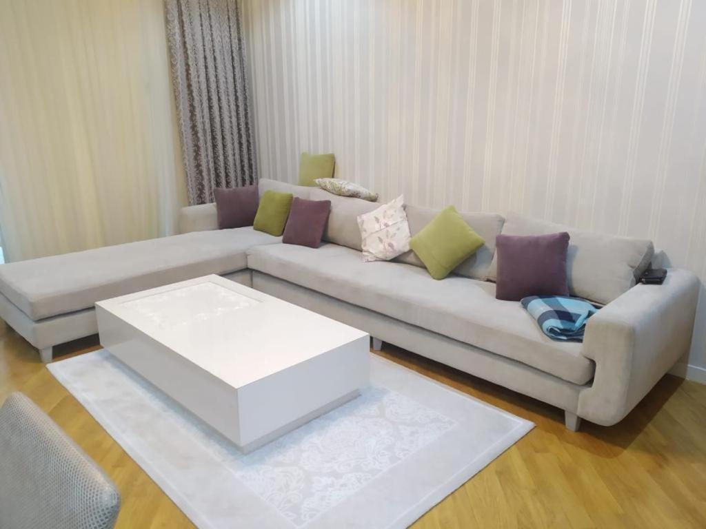 een woonkamer met een bank en een salontafel bij Abmasador Apartment in Baku