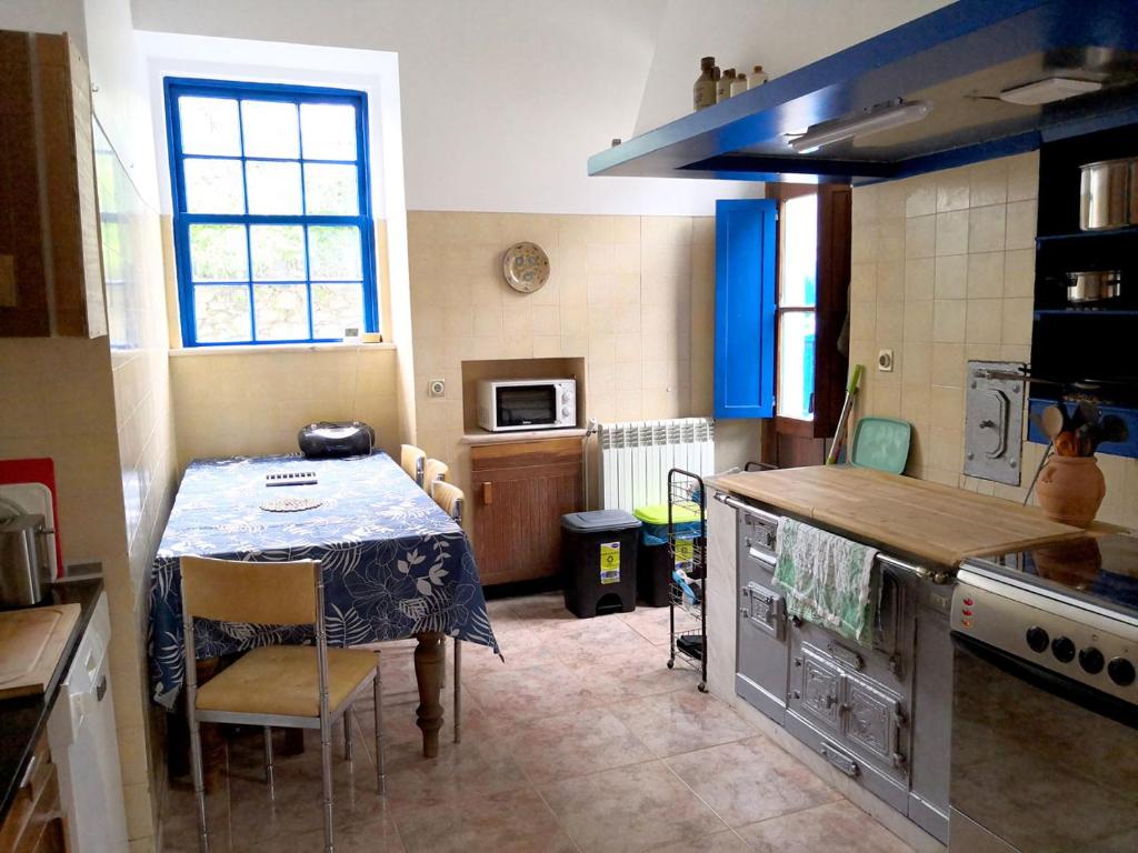 a kitchen with a table and a table and a kitchen with a tableablish at Bom Caminha - Private Albergue for Pilgrims in Caminha