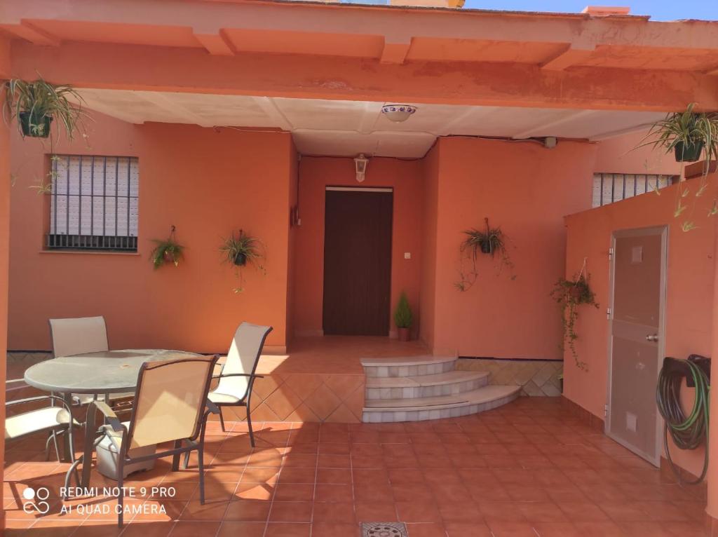 a patio with a table and chairs in a building at Casa del Poniente Playa y Terraza in Lepe
