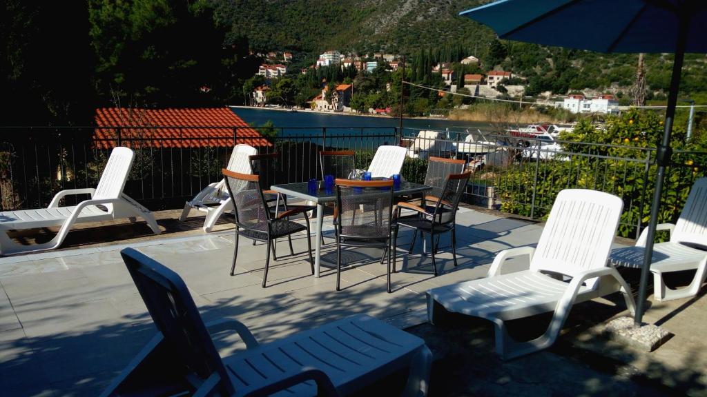 grupa krzeseł i stół z parasolem w obiekcie Beautiful 3-Bed Villa in Zaton Mali w mieście Zaton Doli
