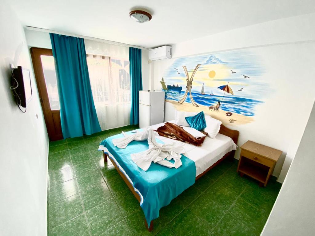a bedroom with a bed with a painting on the wall at Vila Tanase in Costinesti