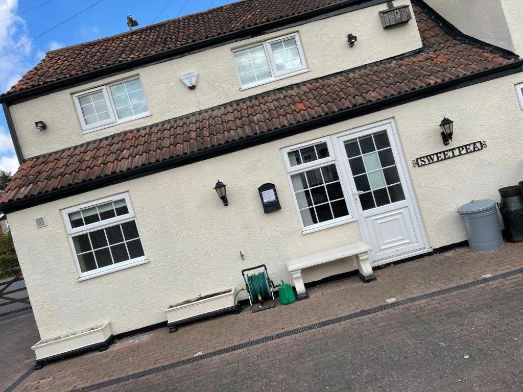 un edificio blanco con un banco delante en Sweetpea Cottage in Louth, en Louth