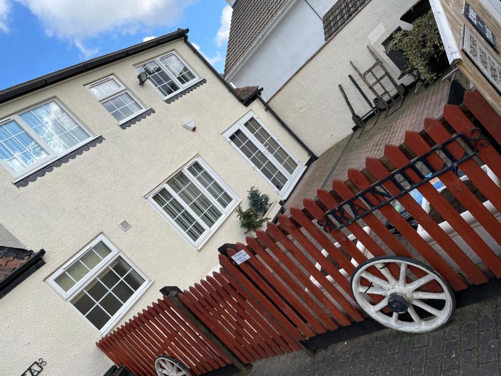 a house with a wooden fence in front of it at Rain Hill Cottage in Louth in Louth
