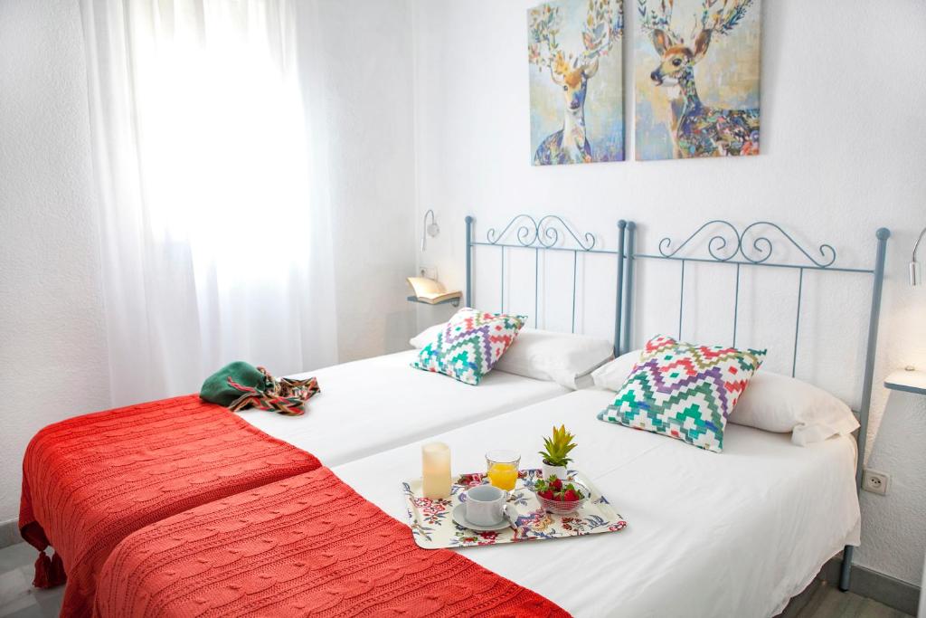 - une chambre avec 2 lits jumeaux et des assiettes de nourriture dans l'établissement Apartamentos RG Arenal II, à Séville