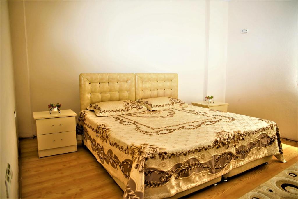 a bedroom with a large bed and a night stand at Kanarya Apart in Trabzon