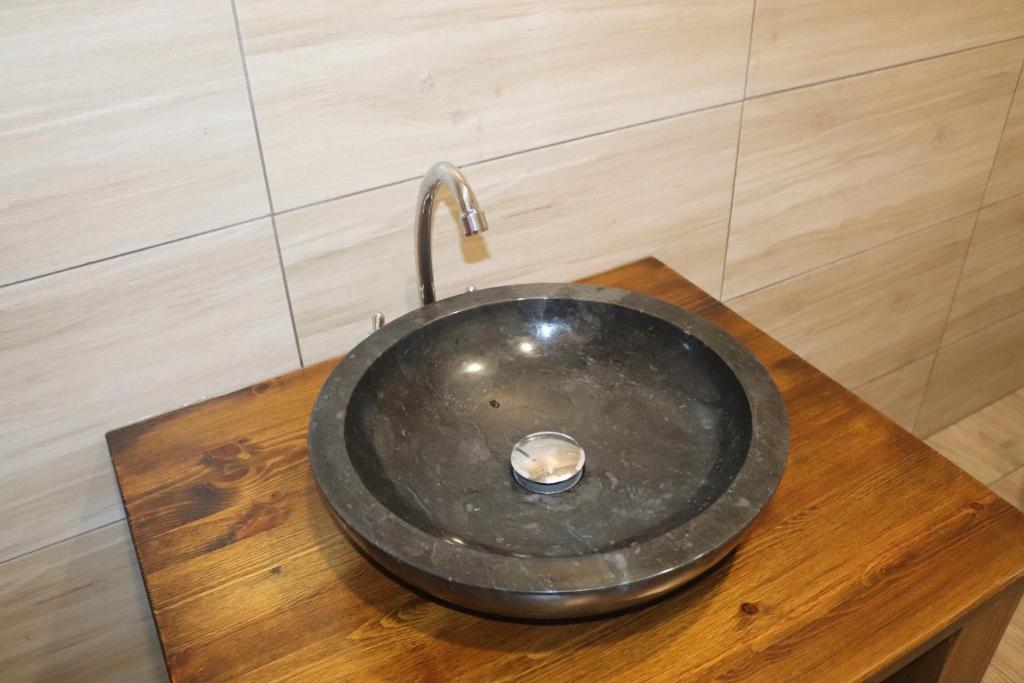a sink with a faucet on top of a wooden table at apartmány Kynast in Albrechtice v Jizerských horách