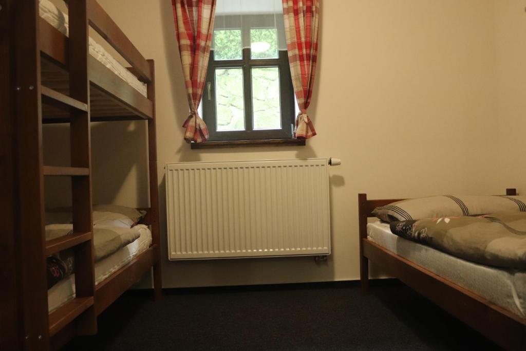 a bedroom with two bunk beds and a window at apartmány Kynast in Albrechtice v Jizerských horách