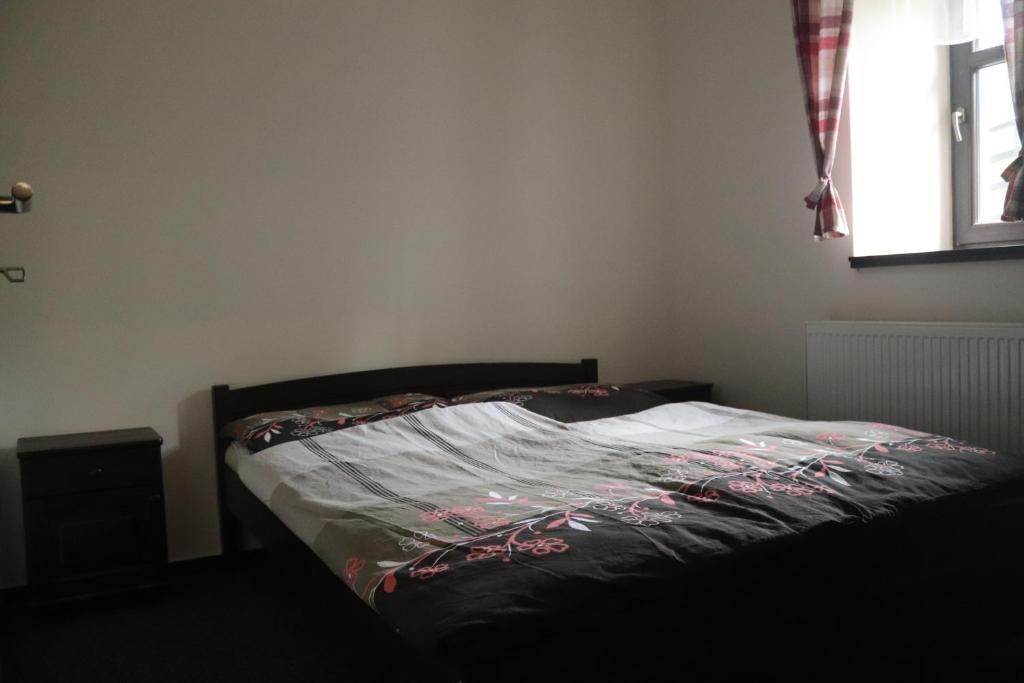 a bed in a bedroom with a bedspread on it at apartmány Kynast in Albrechtice v Jizerských horách